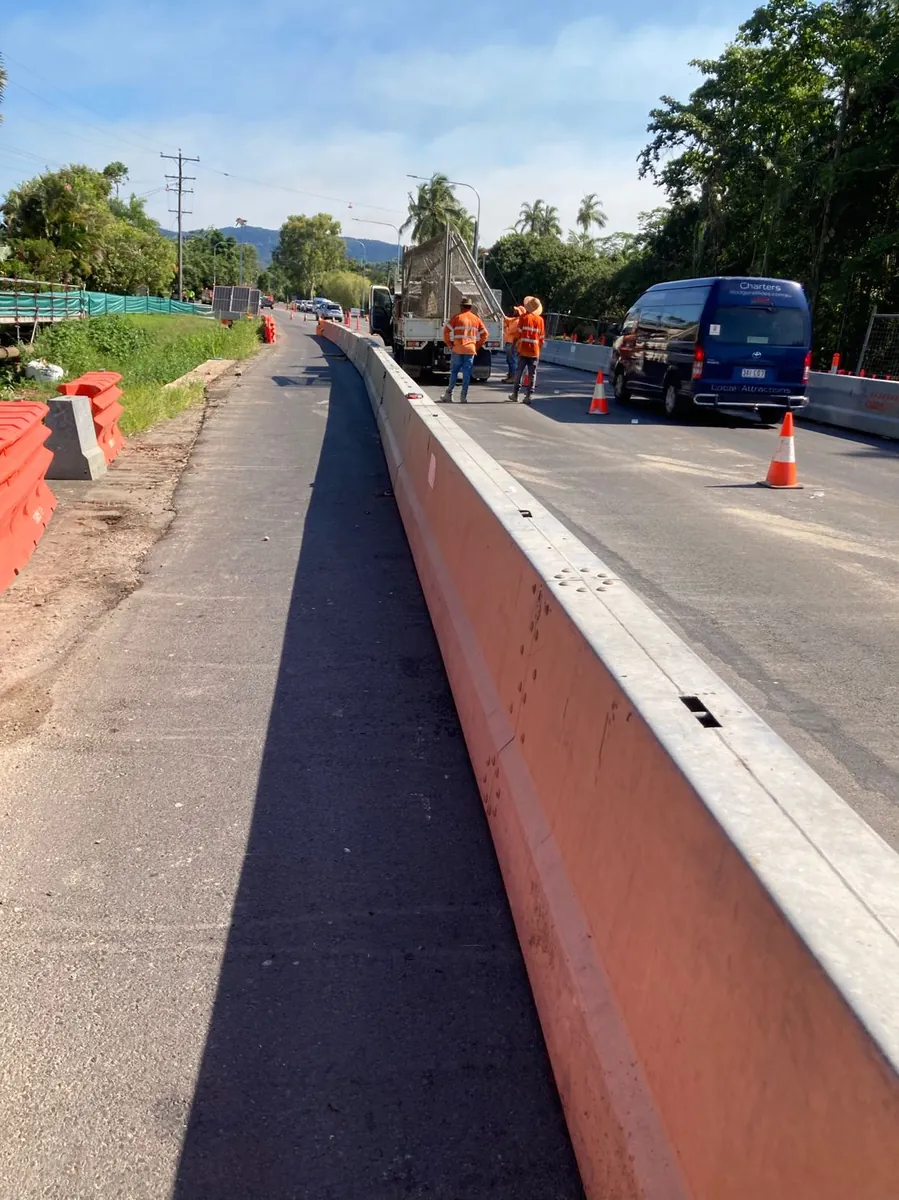 Steel-topped concrete barrier installation on a bridge approach